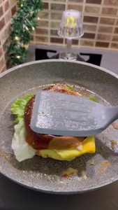Closing the toasted hamburger bun to complete the egg sandwich.