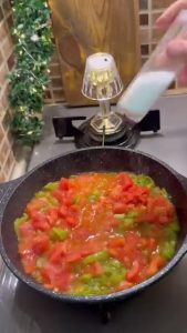 Simmering tomatoes and peppers to create a rich breakfast sauce.