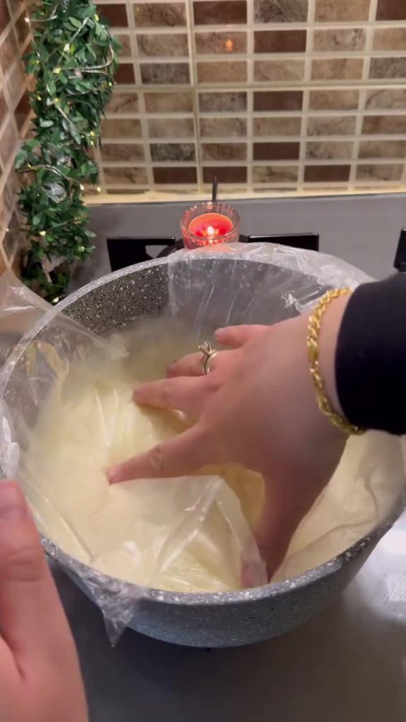 Covering the pudding with plastic wrap touching the surface to prevent skin formation.
