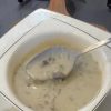 A bowl of creamy mushroom soup garnished with fresh dill and black pepper.