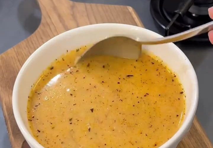 A bowl of creamy vermicelli soup garnished with sizzling mint butter and garlic.