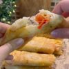 A plate of golden brown crispy fried Turkish börek filled with sucuk and melted cheese.