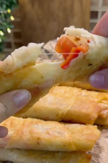 A plate of golden brown crispy fried Turkish börek filled with sucuk and melted cheese.