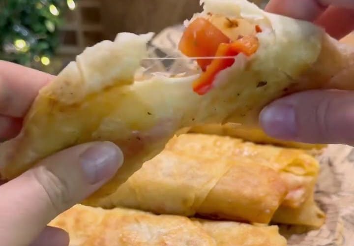 A plate of golden brown crispy fried Turkish börek filled with sucuk and melted cheese.