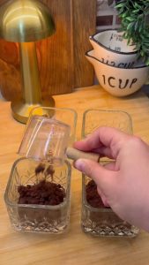 Adding crumbled ready-made sponge cake into the bottom of glass serving cups.