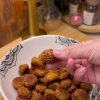 A close-up shot of golden-brown crunchy Turkish sesame bite cookies (Lokmalık Susamlı Kurabiye) served on a plate with a traditional glass of Turkish tea.