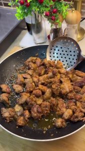 Placing freshly fried crispy chicken livers on a paper towel to drain excess oil.