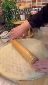 Dropping fresh homemade mantı dumplings into a pot of boiling salted water.