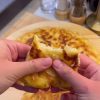 A golden-brown, crispy Turkish pan borek served in wedges on a plate.