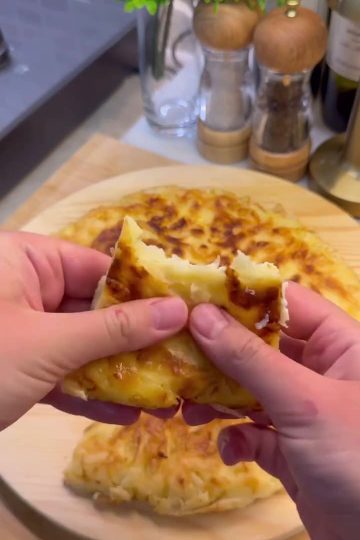 A golden-brown, crispy Turkish pan borek served in wedges on a plate.