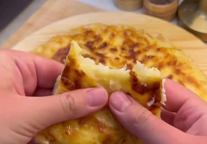A golden-brown, crispy Turkish pan borek served in wedges on a plate.