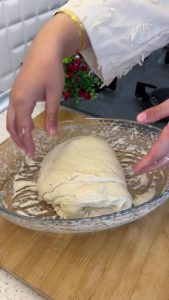 The texture of fermented bread dough showing large air bubbles after multiple folds.