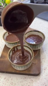 Pouring the 3-ingredient chocolate batter into greased baking molds.