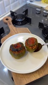 The final result of golden-brown oven-baked Turkish stuffed peppers (Biber Dolması) in a dish.