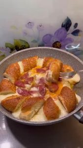 The final presentation of the cheesy simit and egg breakfast skillet with melted cheese.