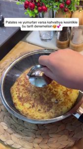 Flipping the omelet to show the perfectly golden-brown and crispy first side.