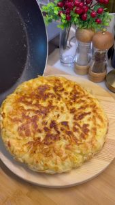 Flipping the golden-brown pan borek to cook the other side until extra crispy.