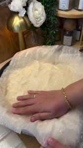Folding the edges of the baklava sheets inward to create a neat edge.