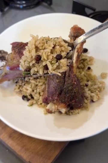 A close-up of fluffy Turkish aromatic rice pilaf garnished with fresh dill and currants.