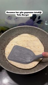 Searing the taco burger in a hot pan with the meat side facing down for a crust.