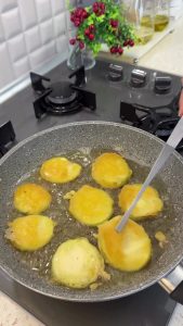 Heating a generous amount of vegetable oil in a large skillet for deep frying.
