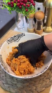 Kneading the bulgur and semolina mixture into a smooth, cohesive dough.