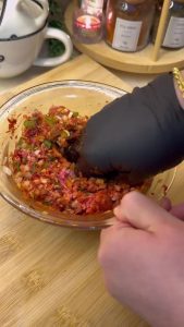 Kneading ground beef with onions, parsley, and Turkish spices in a bowl.