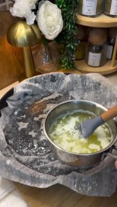 Layering thin baklava sheets in a pan and brushing each with melted butter.