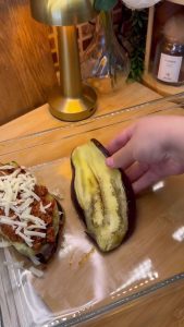 Placing roasted eggplant slices in a dish and topping them with the meat mixture.