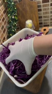 Massaging the cabbage by hand to soften fibers and release juices.