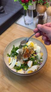 Combining the diced eggs with chopped green onions and parsley in a bowl.