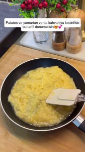 Stirring the eggs, salt, and grated potatoes until the batter is well-combined.