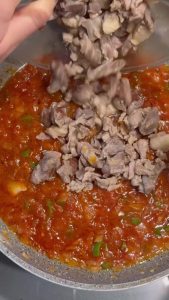 Combining tenderized lamb with a rich tomato and pepper paste sauce.