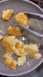 Stirring minced garlic and salt into a bowl of thick Turkish yogurt.