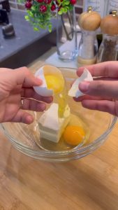 Mixing softened butter, yogurt, and eggs in a large bowl for the pastry dough.