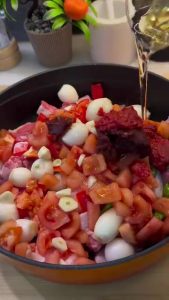 Mixing tomato and pepper paste with water and oil for the sauce.