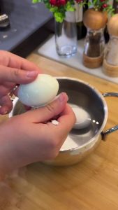 Peeling the shells off hard-boiled eggs for the breakfast salad base.