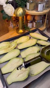 Brushing eggplant slices with olive oil and roasting them on a baking sheet.