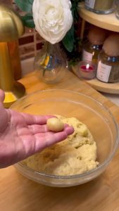 Hand-rolling small, marble-sized pieces of dough for lokmalık cookies.