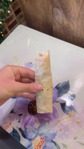 Rolling the yufka into a cigar shape for the pizza-style appetizer.