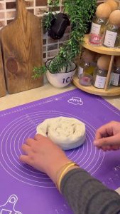 Rolling the yufka and cheese into a long thin log shape.