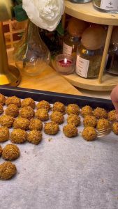 Rows of sesame-coated cookie bites ready for the oven on a tray.