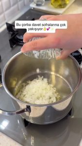 Sautéing diced onions in a pot with extra virgin olive oil for the soup base.