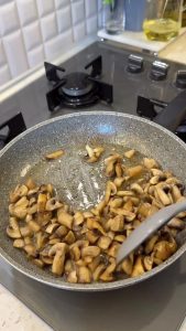 Sautéing sliced mushrooms in a pan until the water evaporates and they turn golden.