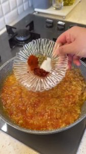 Adding garlic, thyme, and red pepper flakes to the mashed vegetable mixture.
