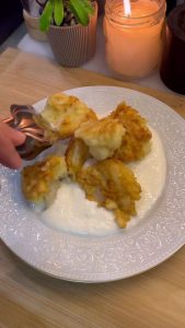 Plating crispy cauliflower bites with a side of creamy garlic yogurt dip.