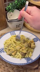 A finished bowl of creamy curry chicken and mushroom pasta ready to serve.