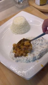 Plating the final Alinazik kebab by adding hot meat sauce over the cool base.