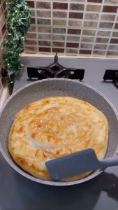 Serving a crispy, hot pan-fried rose börek on a breakfast plate.