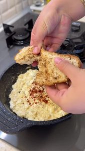 Serving the final creamy yogurt and egg dish with crispy toasted bread and tea.